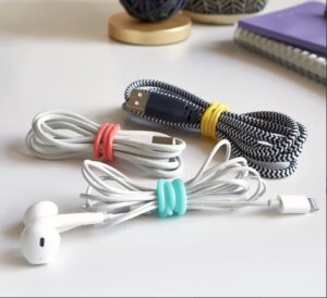 Three cables and a pair of earbuds, each wrapped with a colorful silicone band to keep cords tangle-free."